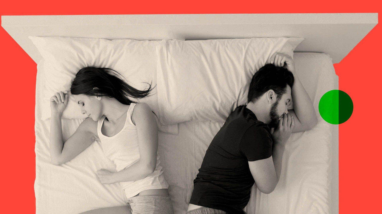 A woman and a man sleeping in bed back to back, top view