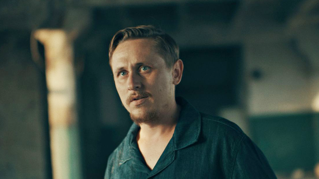 muškarac u košulji gleda u kameru