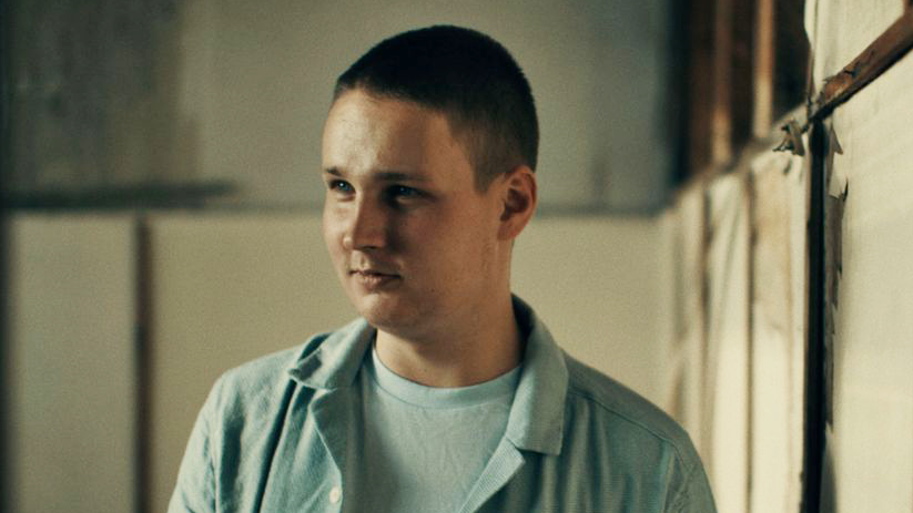 mlađi muškarac u plavoj košulji u napuštenom skladištu