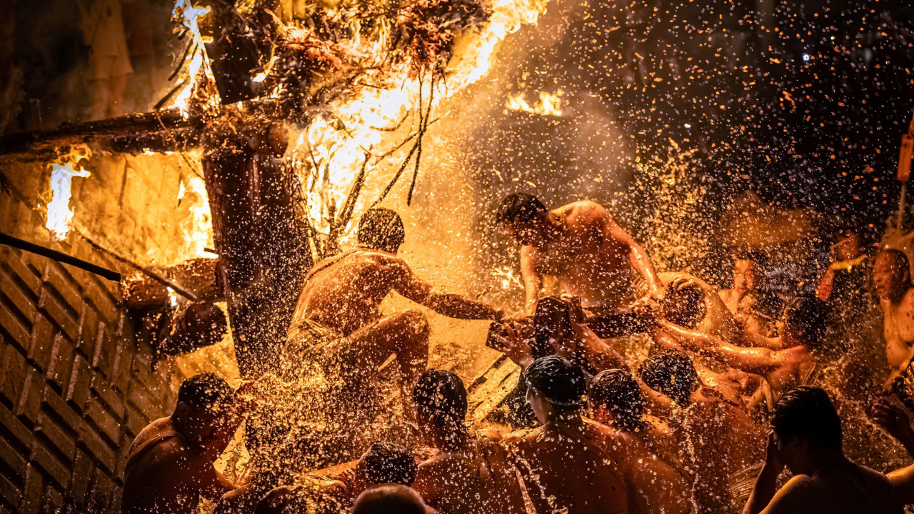 Polugoli Japanci skaču u reku usred žestoko zapaljenih baklji koje šalju varnice na sve strane.