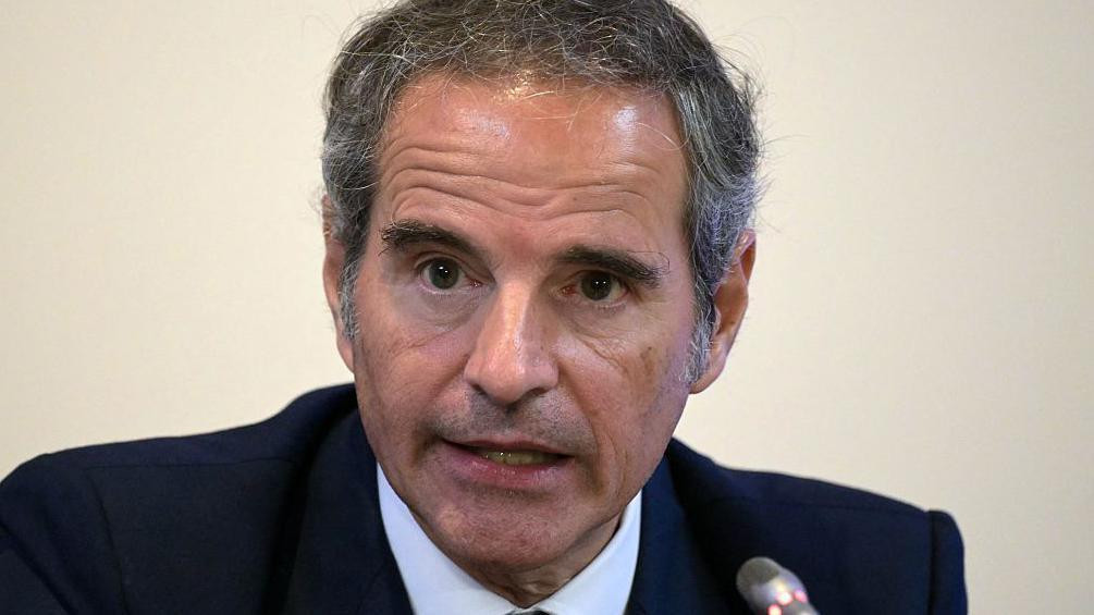 Šef IAEA Rafael Grosi, u teget odelu, beloj košulji i plavoj kravati, govori pred mikrofonom.