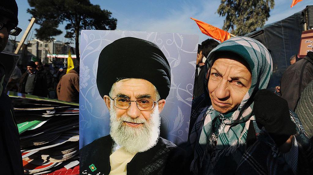 Iranka pozira sa portretom vrhovog lider Hamneija 