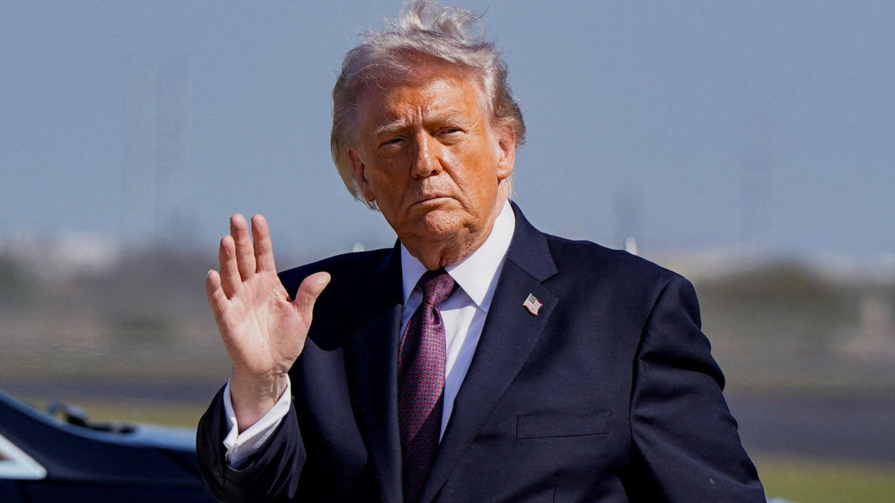 Donald Tramp, ispred aerodroma maše prisutnima - nosi tamno odelo sa bordo kravatom 