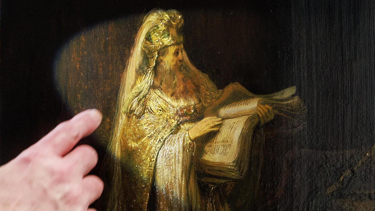 A researcher's finger points at a close-up of the figure of Zacharias from Rembrandt’s Vision of Zacharias in the Temple (1633)
