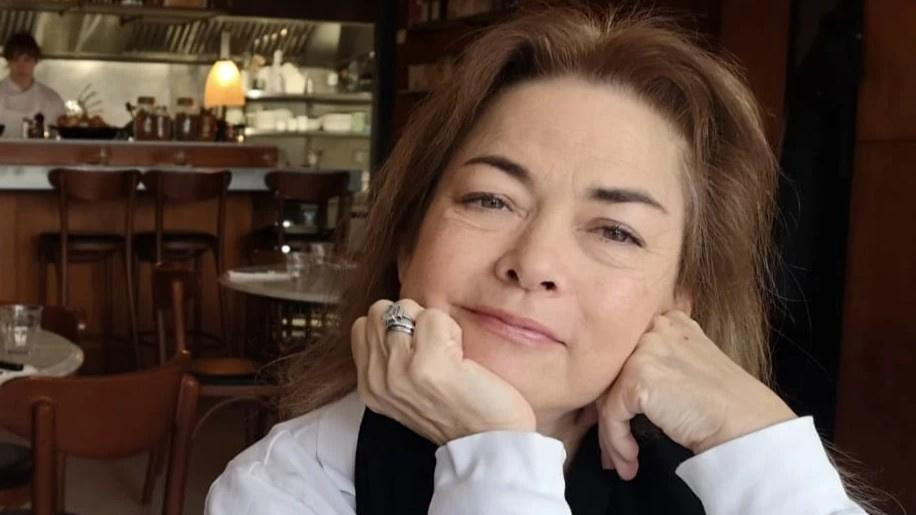 Žena u beloj blues sedi i pozira
