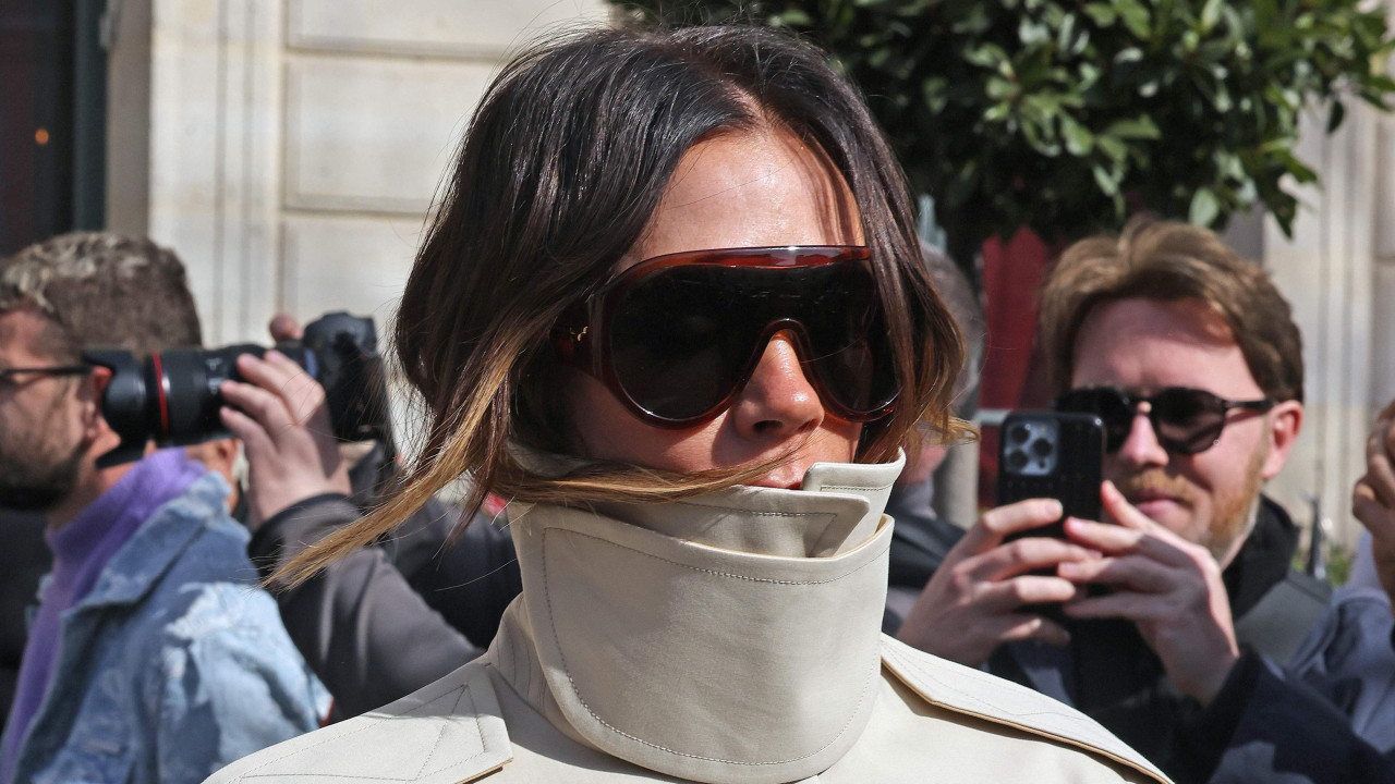 Viktorija Bekam u bež jakni sa levkastim izrezom i naočarama za sunce izlazi iz hotela tokom Nedelje mode u Parizu