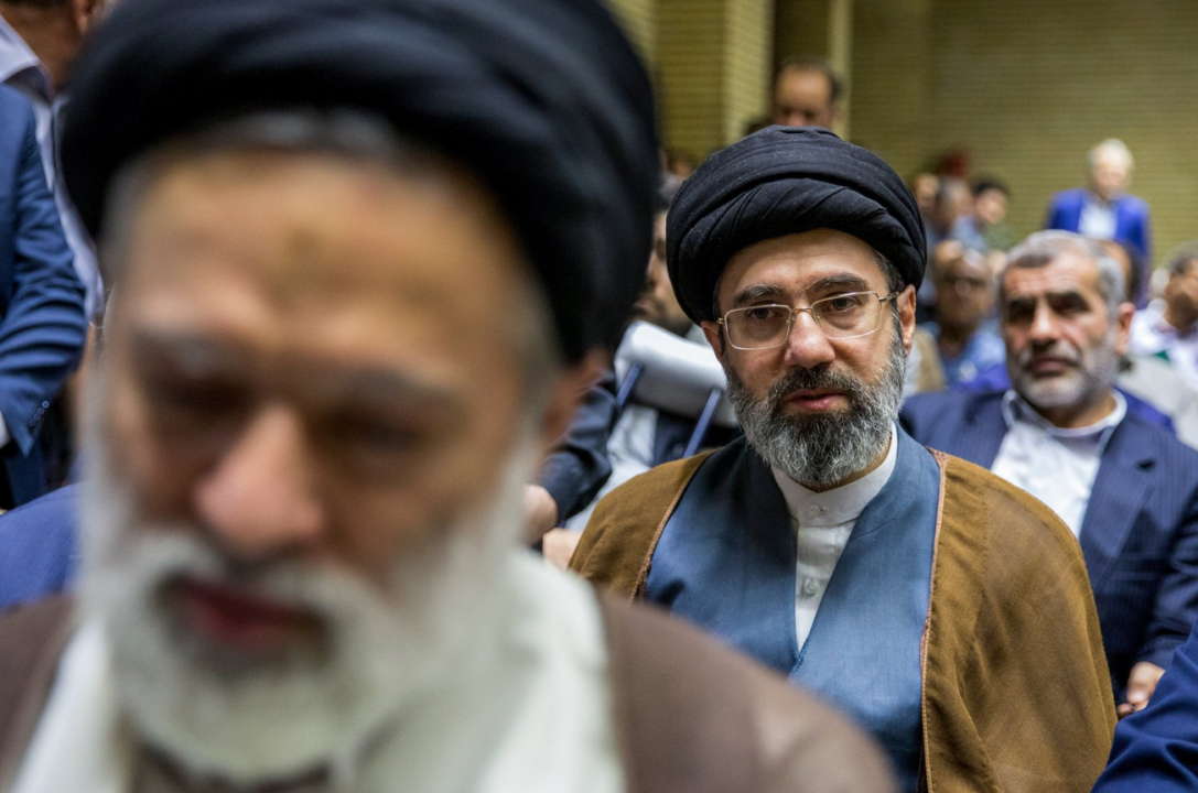 Modžtaba Hamenei u smeđem ogrtaču i crnom turbanu gleda u kameru, ima naočale