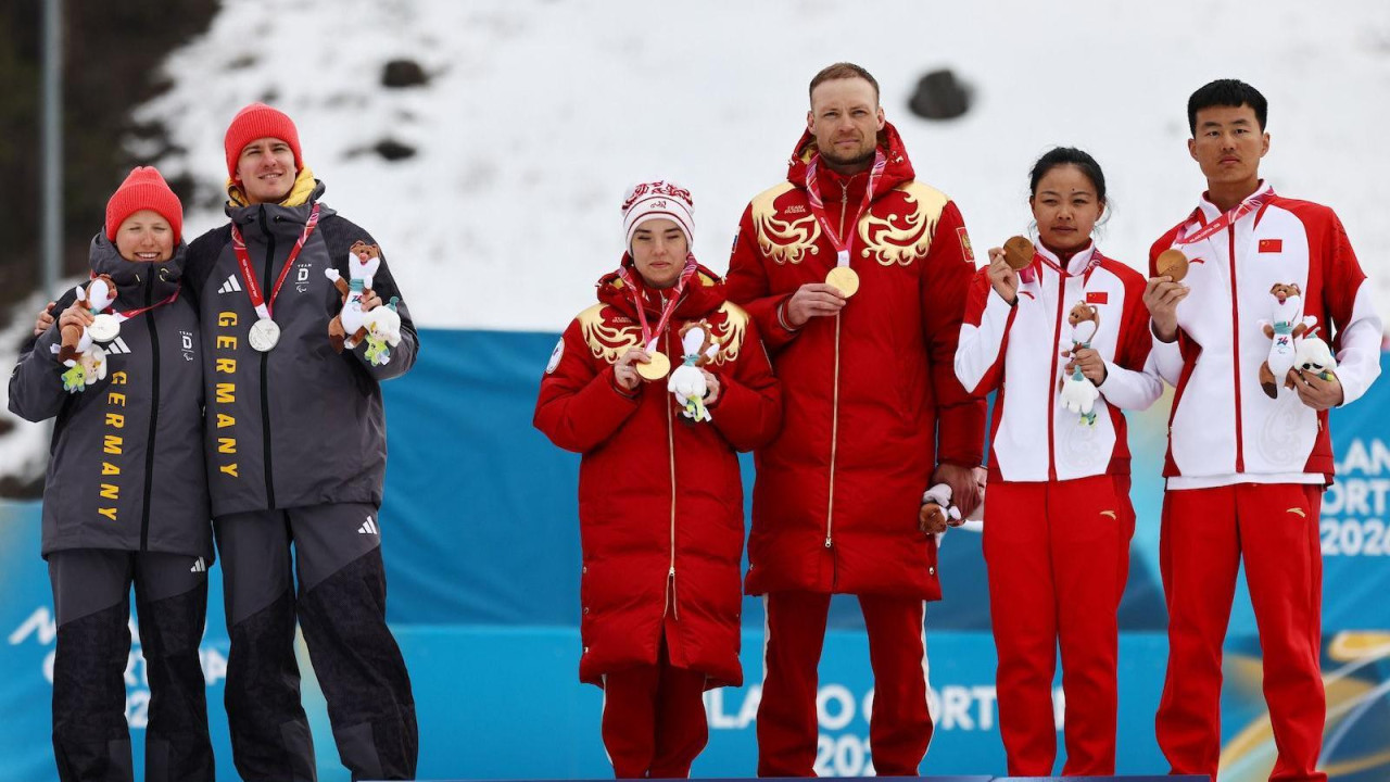 Nemački sportisti (levo) držali su distancu od ruskih (desno) tokom fotografisanja posle ceremonije dodele medalja, Zimske paraolimpijske igre