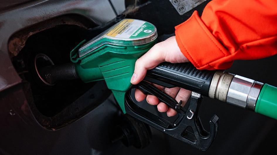 čovek toči gorivo u kola 
