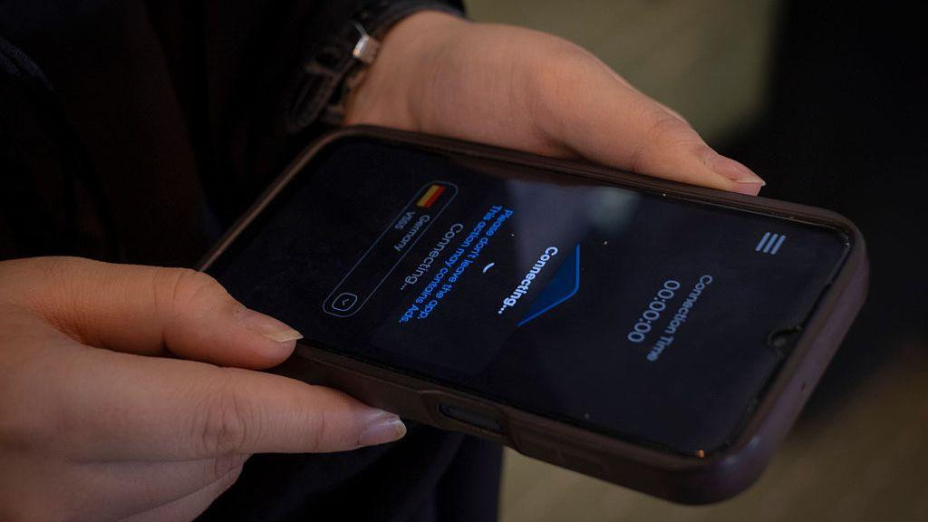 žena drži telefon a na ekranu piše "povezujem se" 
