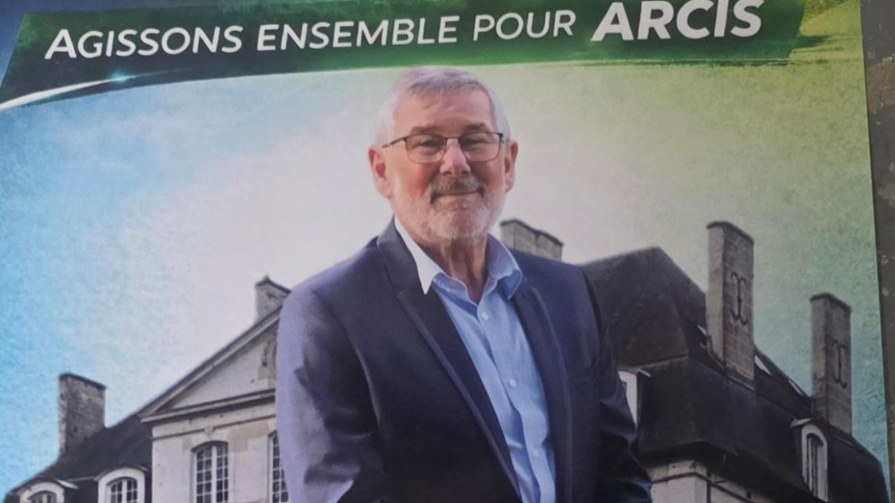 Izborni plakat prikazuje čoveka u plavom sakou i košulji i sedoj bradi