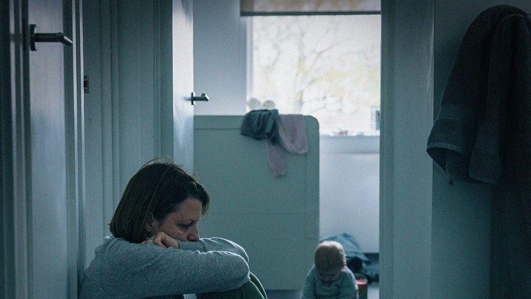 A mother slumped outside her child's bedroom