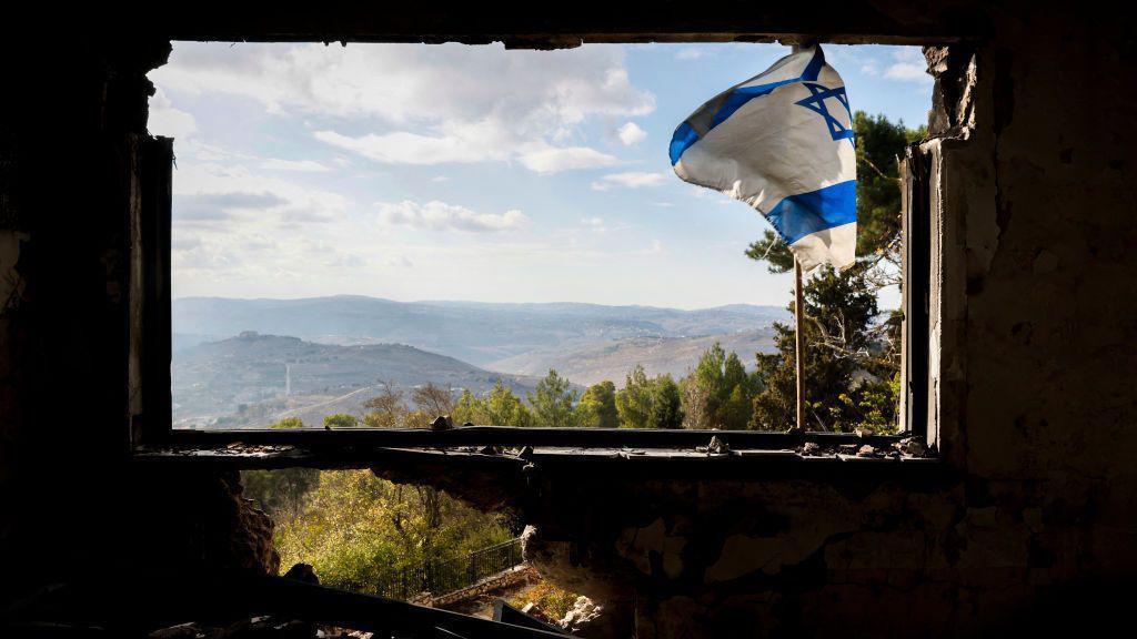 Izraelska zastava vijori se na prozoru zgrade koja je oštećena tokom rata između Izraela i Hezbolaha u kibucu Menara na severu Izraela 28. novembra 2024. godine.