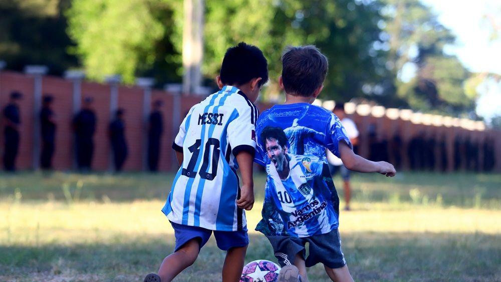 dečaci igraju fudbal u dresovima Argentine