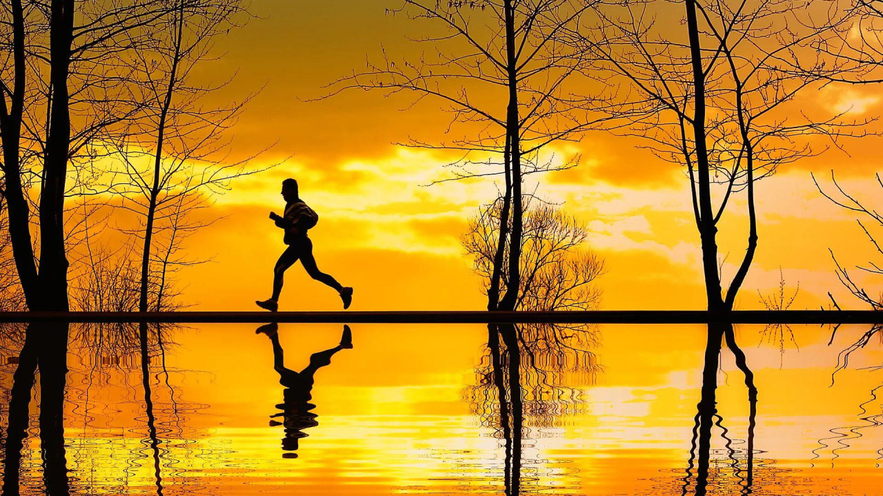 Čovek koji trči uz zalazak sunca