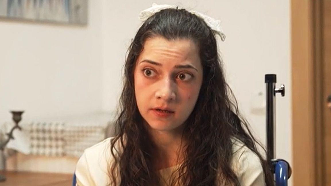 devojka duge kose gleda u kameru