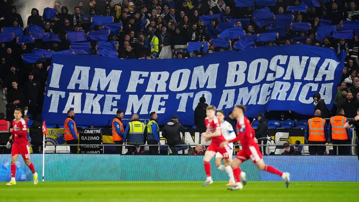 
                    Navijači BiH drže ogroman transparent na plavom platnu na kojem belim slovima piše na engleskom jeziku stih pesme Dubioza Kolektiva - I am from Bosnia, take me to America
