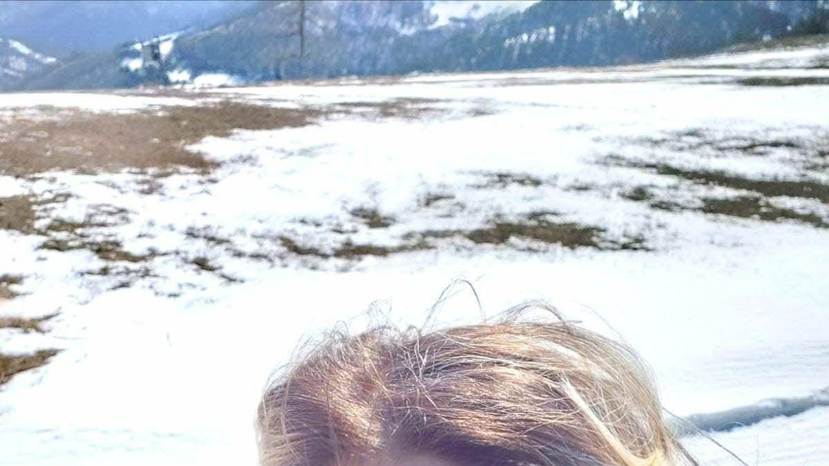 Nikolina Crnogorac fotografiše samu sebe, iza nje se vidi sneg, nosi crnu jaknu ima smeđu kosu 