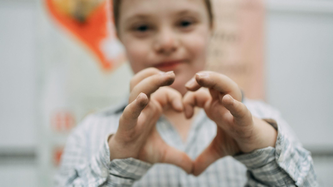dečak u kariranoj košulji pokazuje šakama šakama 