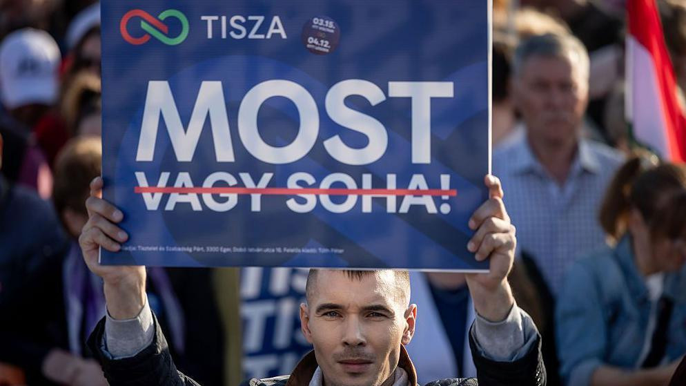 Mađarov pristalica drži transparent na kojem piše „Sad”, dok su reči „ili nikad” precrtane