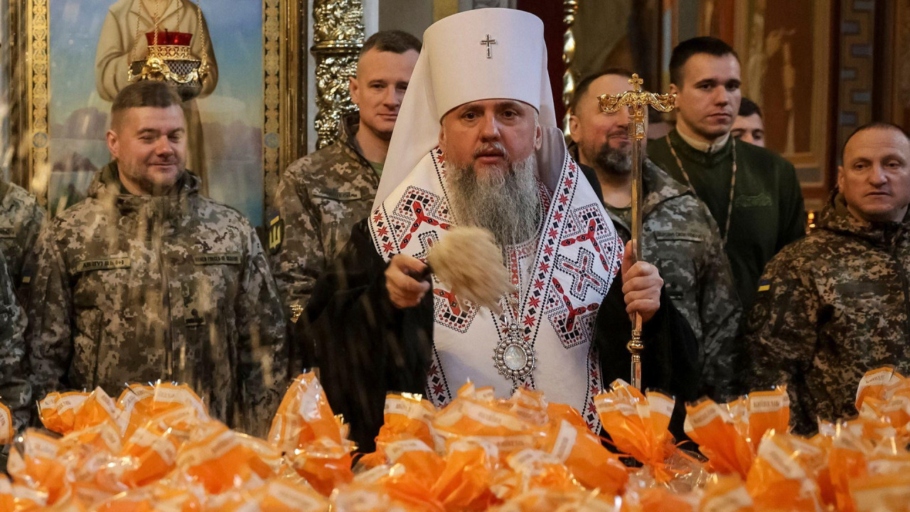 
                    Metropolitan Epiphanius I, head of the Orthodox Church of Ukraine, sprinkles holy water to bless Easter cakes which are to be transferred to Ukrainian servicemen fighting