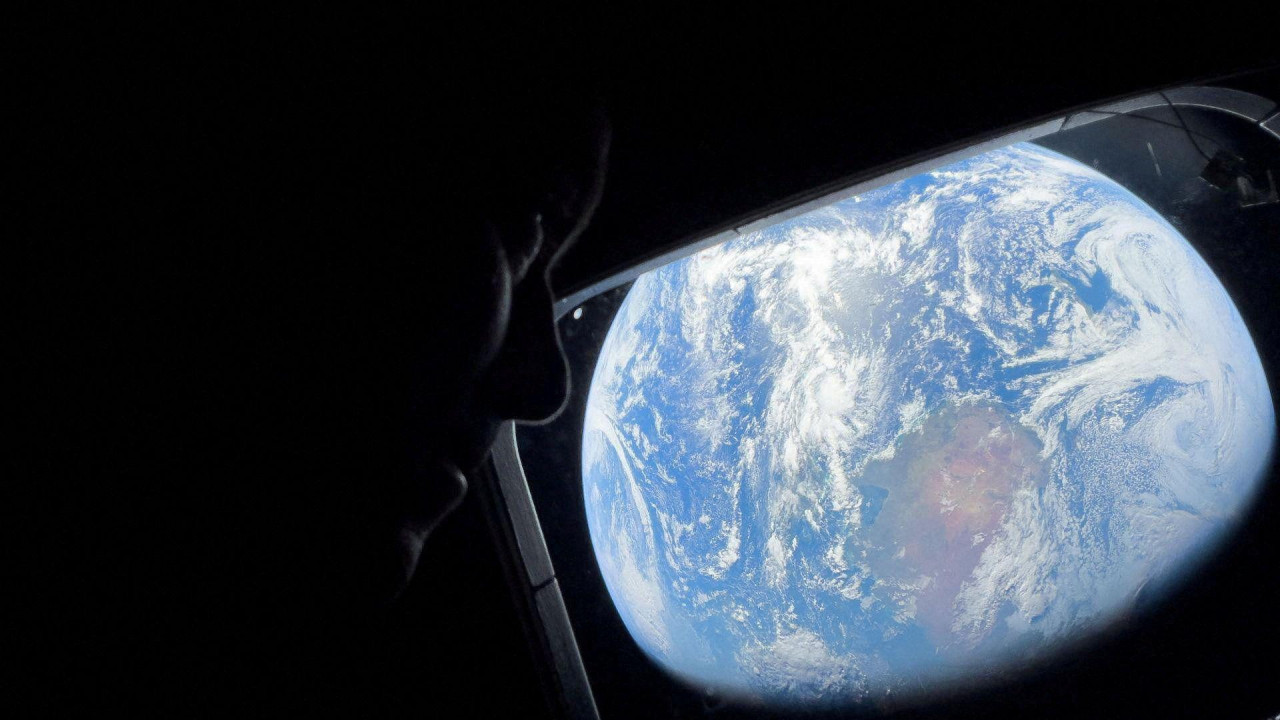Žena gleda kroz svemirsku letelicu planetu Zemlju