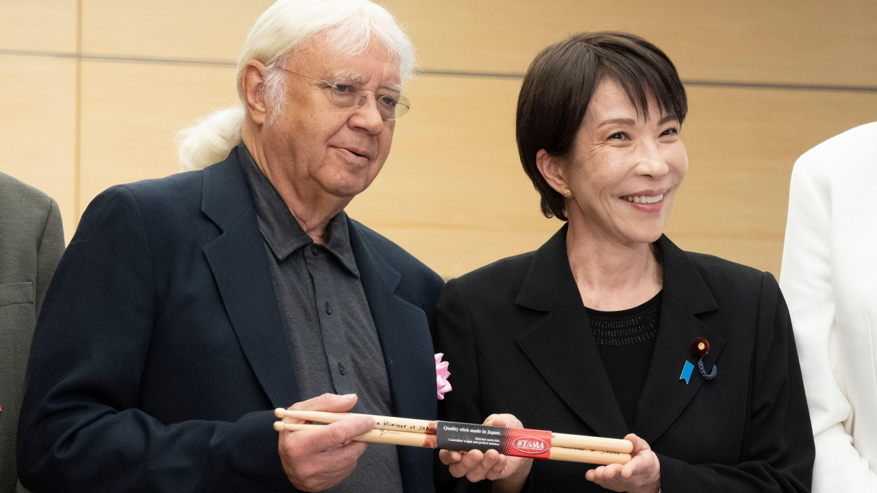 Japanska premijerka nasmejano drži palice sa bubnjarom grupe Dip Parl Ijanom Pejsom