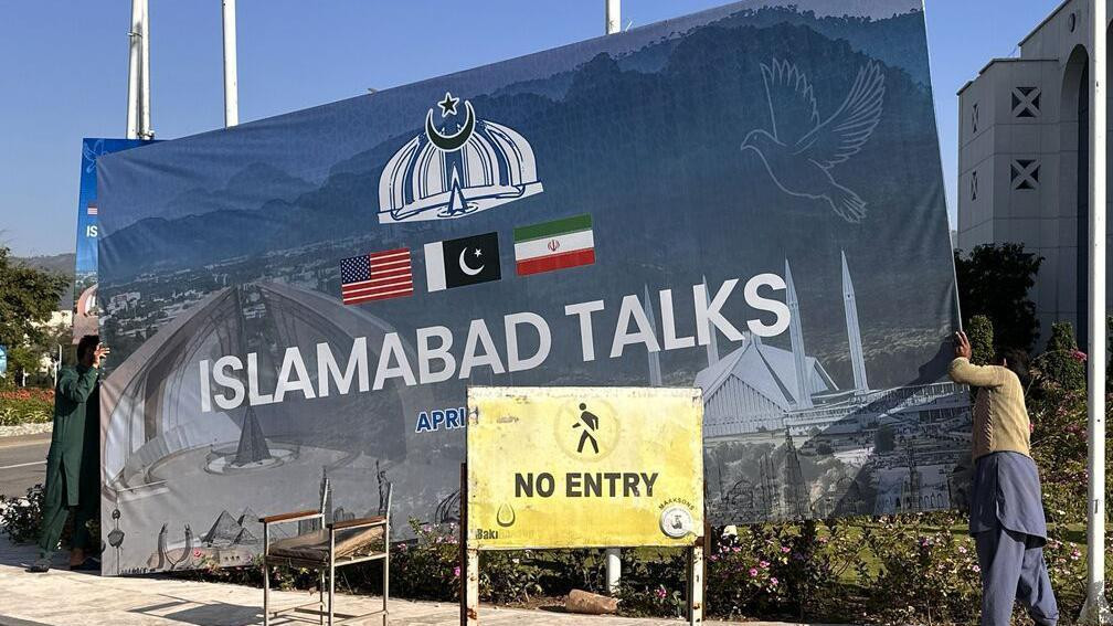 Na velikoj tabli ispisano je Islamabad razgovori, tu su i američka, iranska i pakistanska zastava, na manjoj žutoj tabli na engleskom ispisano - Ne ulazi