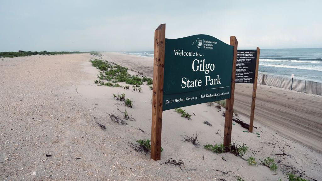 Drveni znak na napuštenoj plaži na kojoj piše: Dobrodošli u Gilgo Bič Park