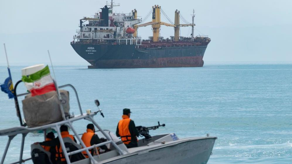 iranski patrolni čamac kreće se ka velikom teretnom brodu