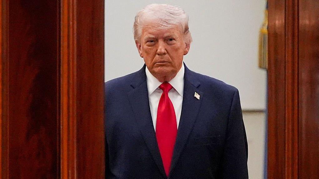 Američki predsednik Donald Tramp u tamno plavom odelu, nosi i crvenu kravatu 