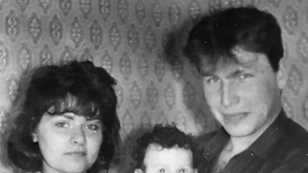 Muškarac i  žena drže bebu u ruci