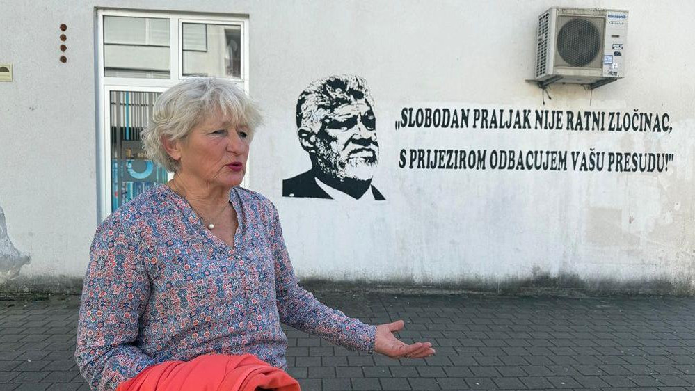žena pored murala osuđenom hrvatskom generalu Slobodanu Praljku, koji se ubio u sudnici Haškog tribunala