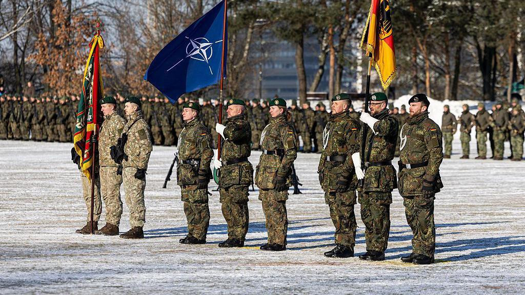 Nemački vojnici u zelenim kamuflažnim uniformama na paradi i sa zastavom NATO-a tokom ceremonije povodom proširenja nemačkog vojnog angažmana u Litvaniji 4. februara 2026. u Kaunasu