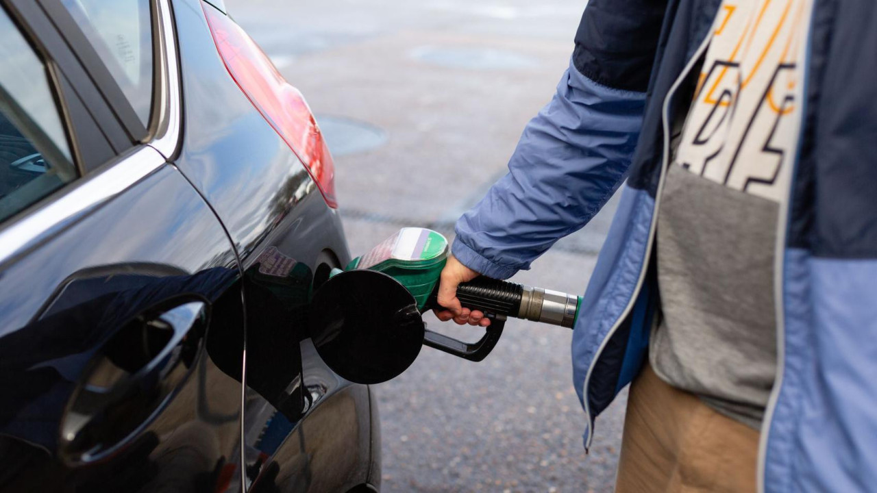 A man filling up his car at a filling station