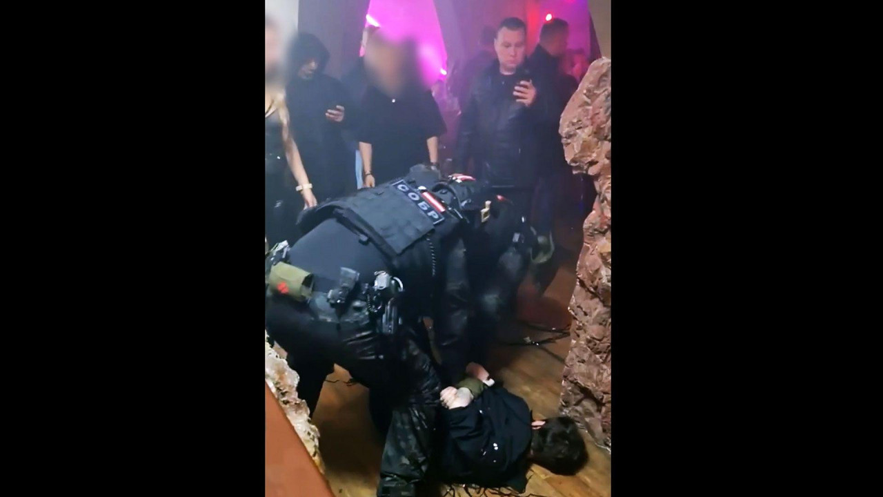 Pripadnici policije drže gosta prikovanog za pod