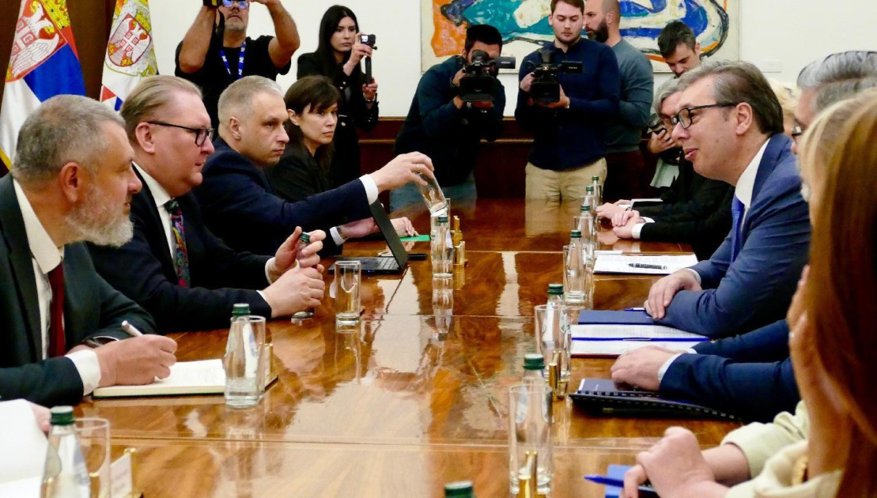 grupe ljudi sede za stolom u odelima jedni preko puta drugih, na zvaničnom sastanku ukrajinske i srpske delegacije