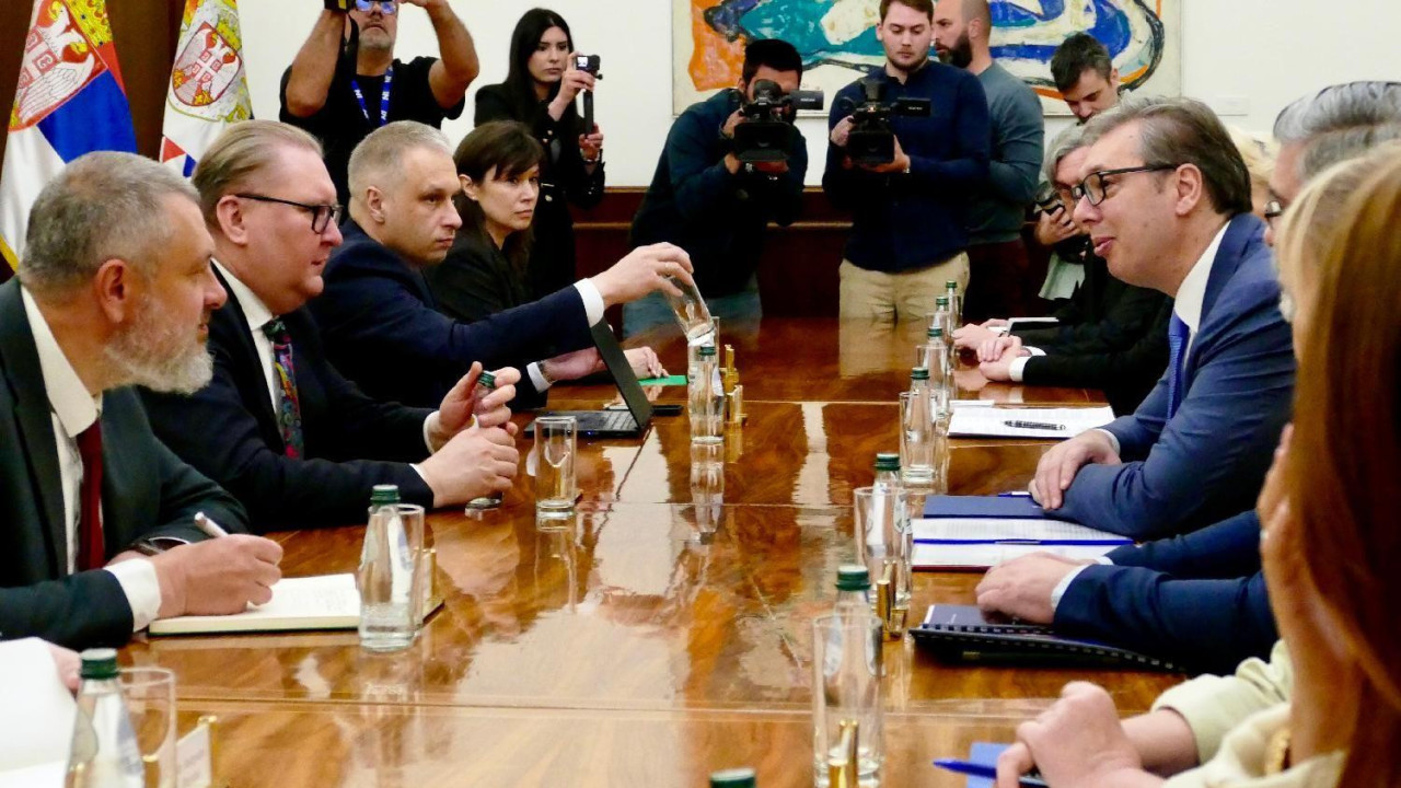 grupe ljudi sede za stolom u odelima jedni preko puta drugih, na zvaničnom sastanku ukrajinske i srpske delegacije