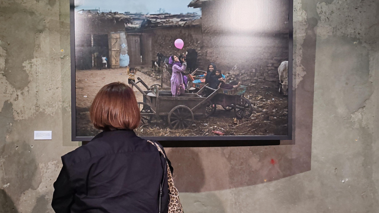 Žena gleda fotografiju dece koja s eigraju balonima