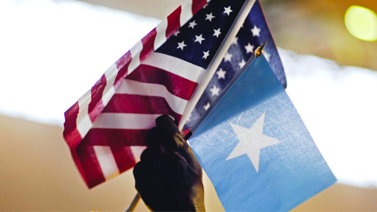 Muškarac drži američku i somalijsku zastavu