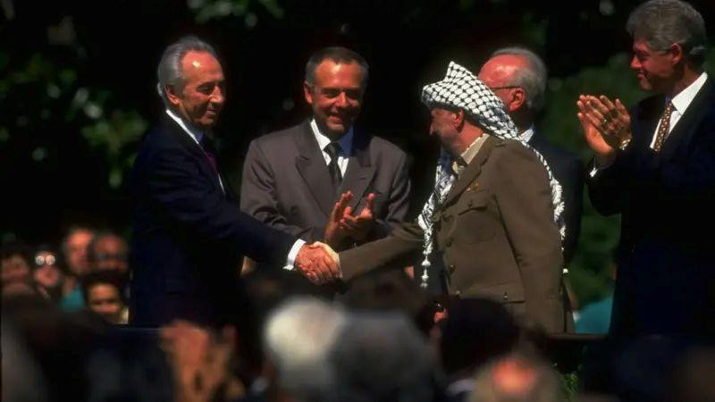Lider PLO Jaser Arafat (desno) rukuje se sa izraelskim ministrom spoljnih poslova Šimonom Peresom