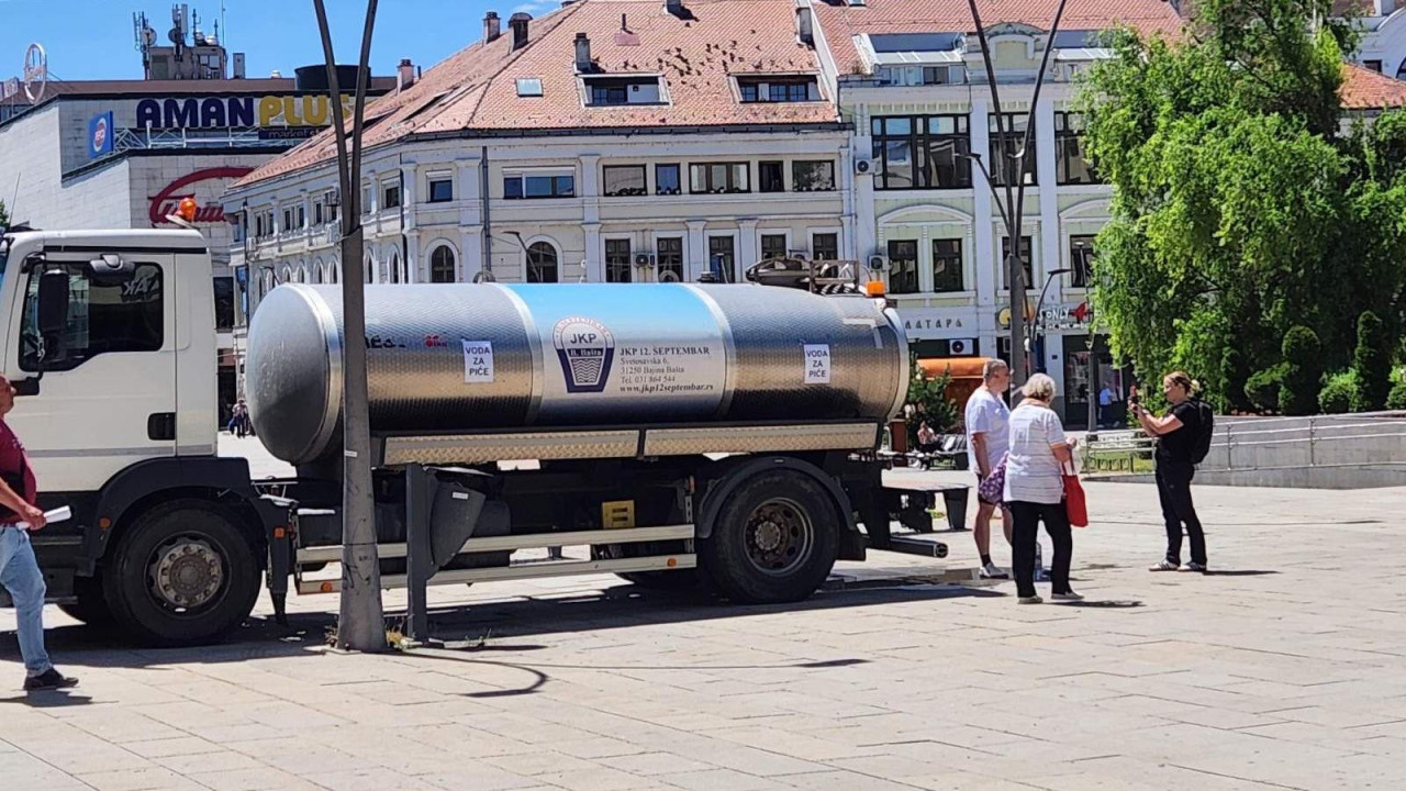 Cisterna za vodu u centru grada, oko nje ljudi