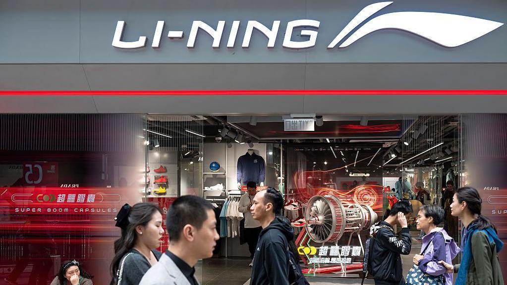 ljudi hodaju pored Li-Ning prodavnice u Kini 