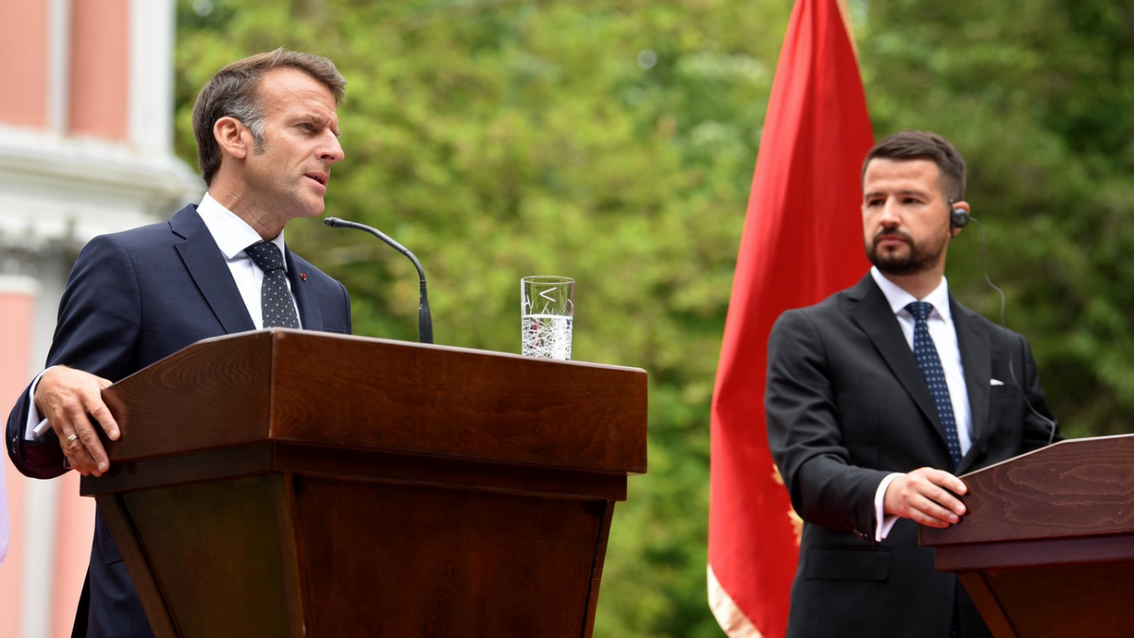 Dva muškarca govore pred govornicama, u odelima, iza jednog je crnogorska zastava