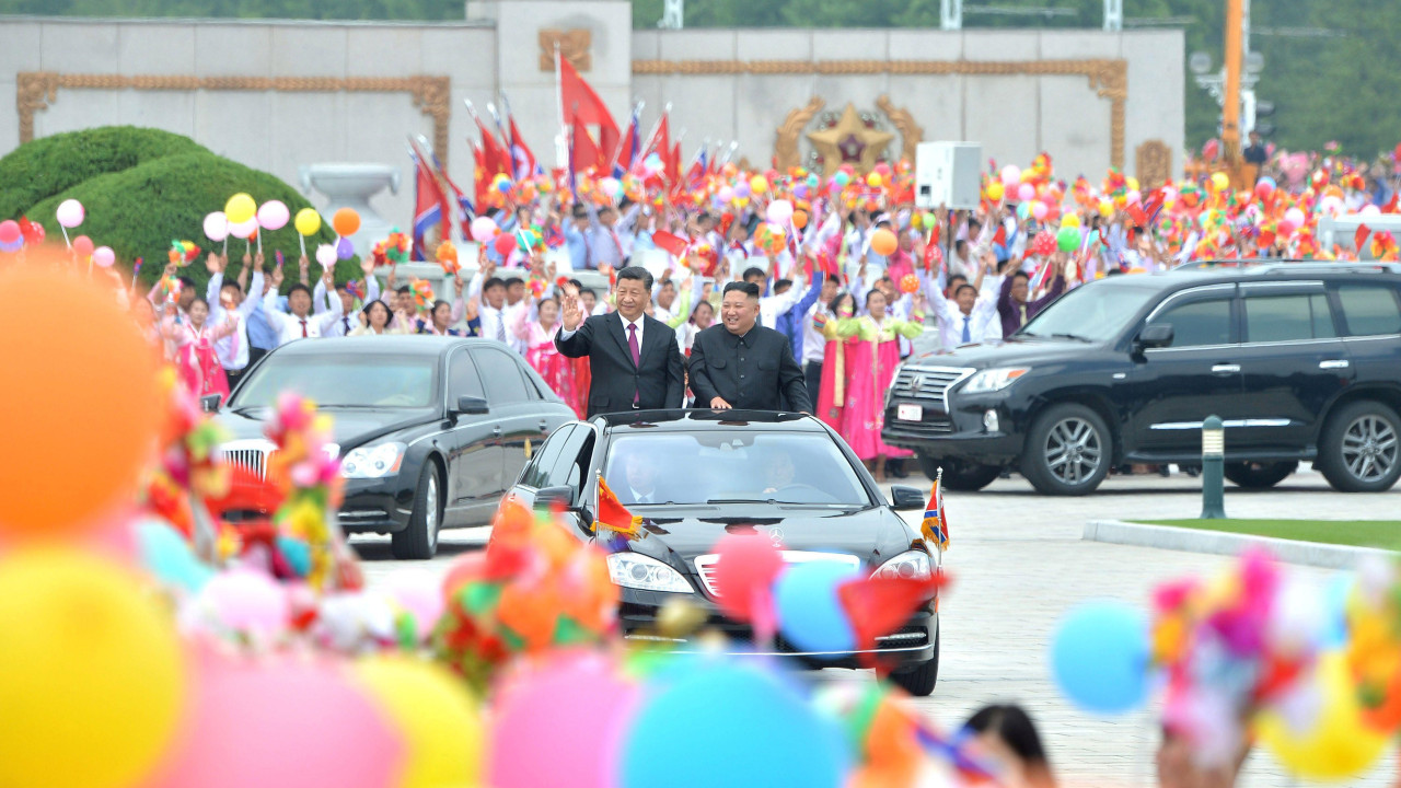 Severnokorejski lider Kim Džong Un i kineski predsednik Si Đinping stoje u povorci i mašu gomili ispred Međunarodnog aerodroma Pjongjang u Severnoj Koreji 21. juna 2019. godine