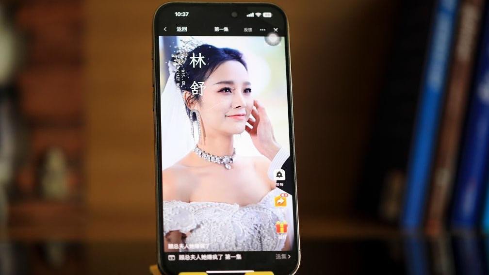 slika na mobilnom telefonu postavljenom vertikalno, prikazuje scenu iz kineske mikrodrame u kojoj se nevesta smeši dok je mladoženja miluje po licu