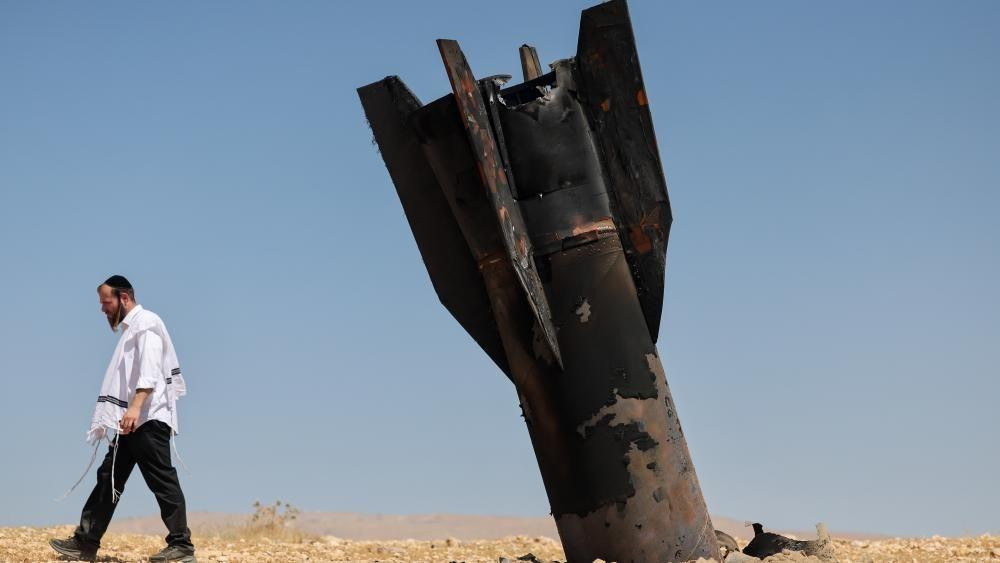 Jevrejin odlazi od ostataka iranske balističke rakete na otvorenom polju u dolini reke Jordan.
