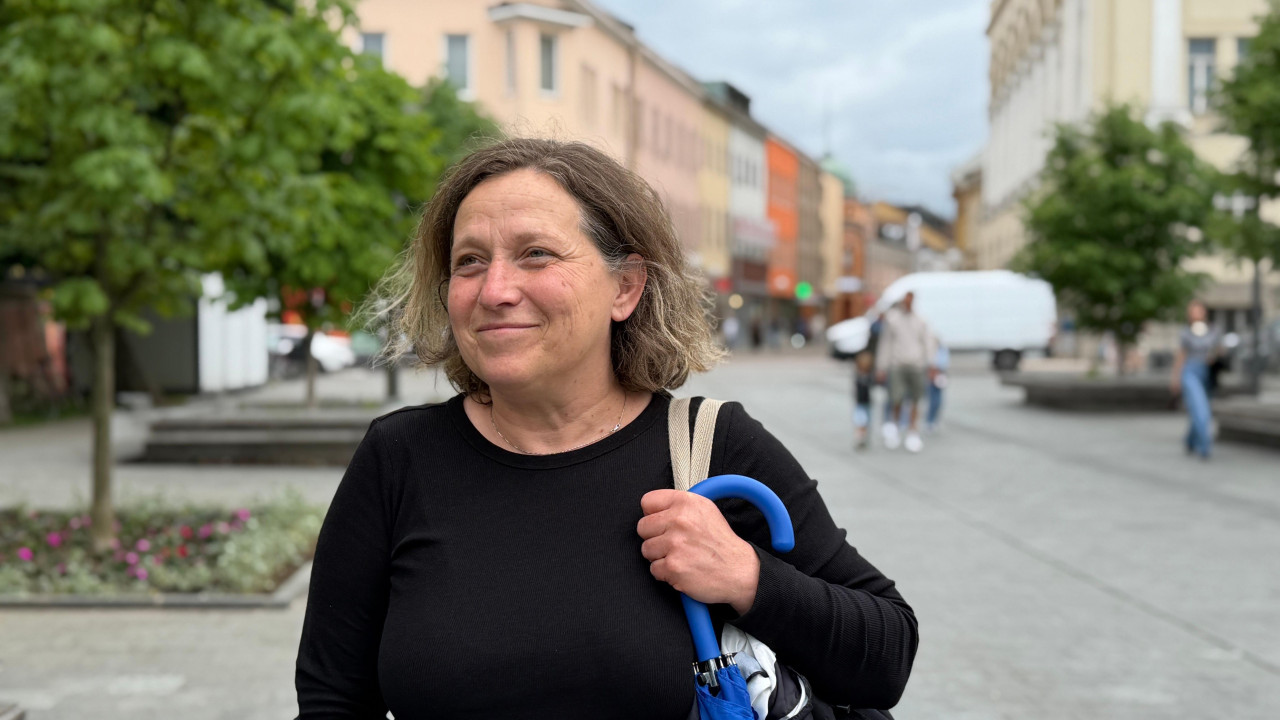 žena plave kose stoji na ulici i gleda u kameru