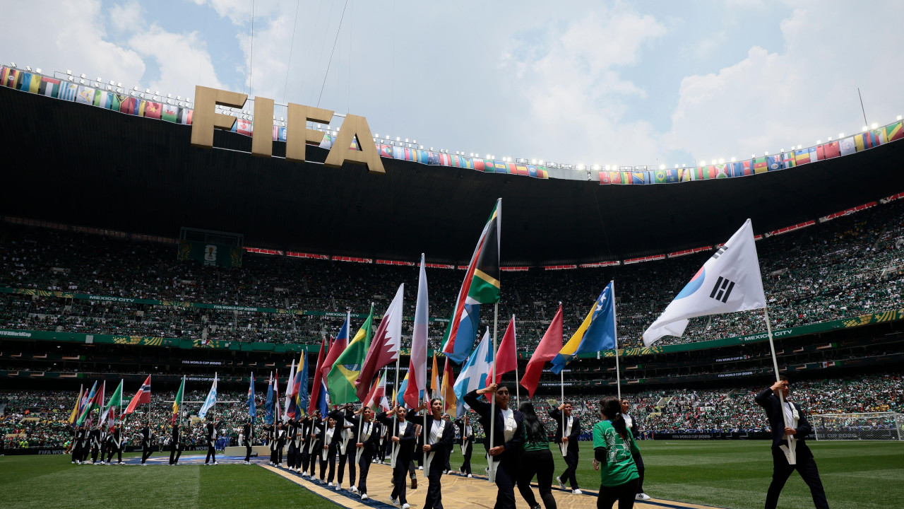 Kolona ljudi sa zastavama učesnica Mundijala na stadionu za vreme otvaranja