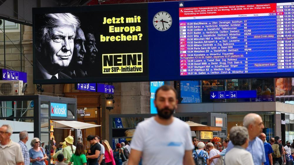 Poster i tabla sa polascima i dolascima aviona i desetine ljudi u zgradi